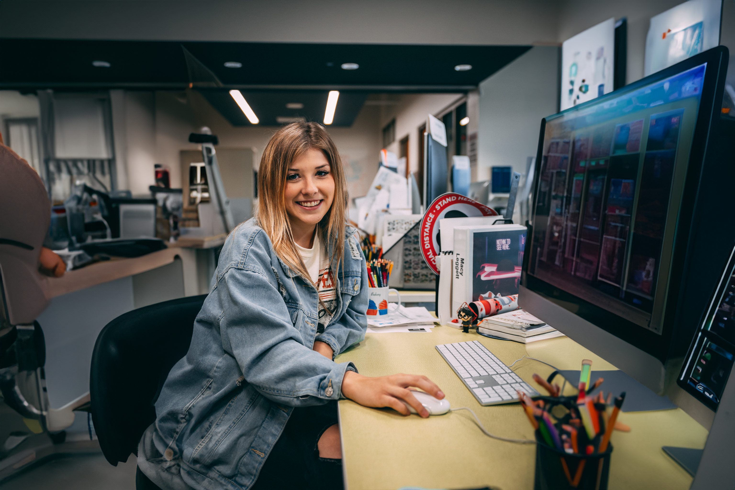 Young graphic design student poses at a computer