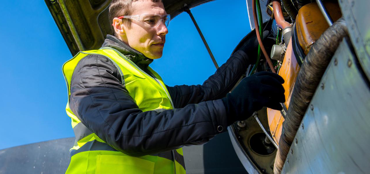 Aviation Maintenance technician examines an aircraft engine