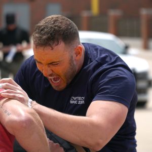 two police academy students practice hand-to-hand combat
