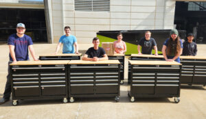 students stand with toolboxes